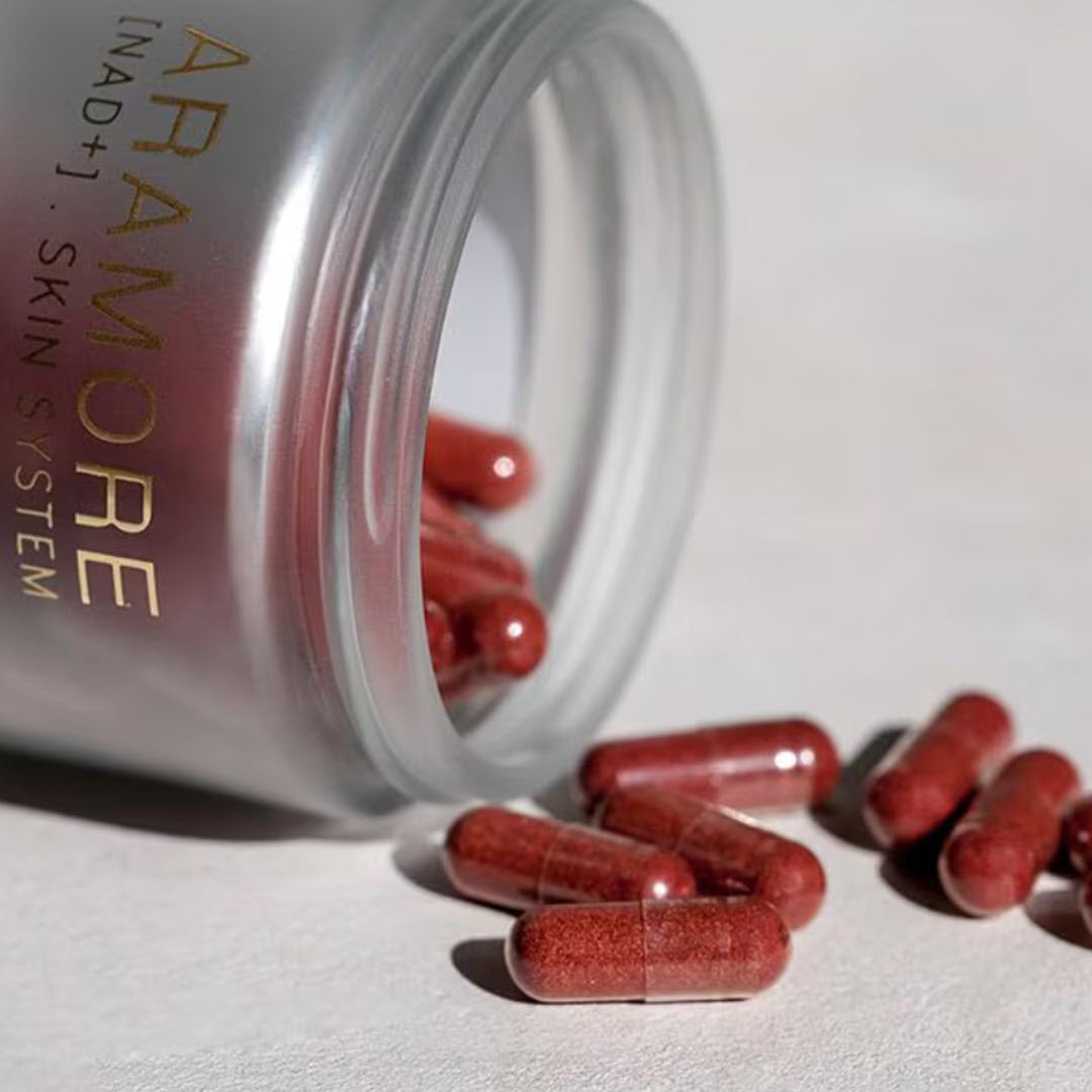 Aramore NAD+ Cell Energizing Supplement capsules spilling out of the jar