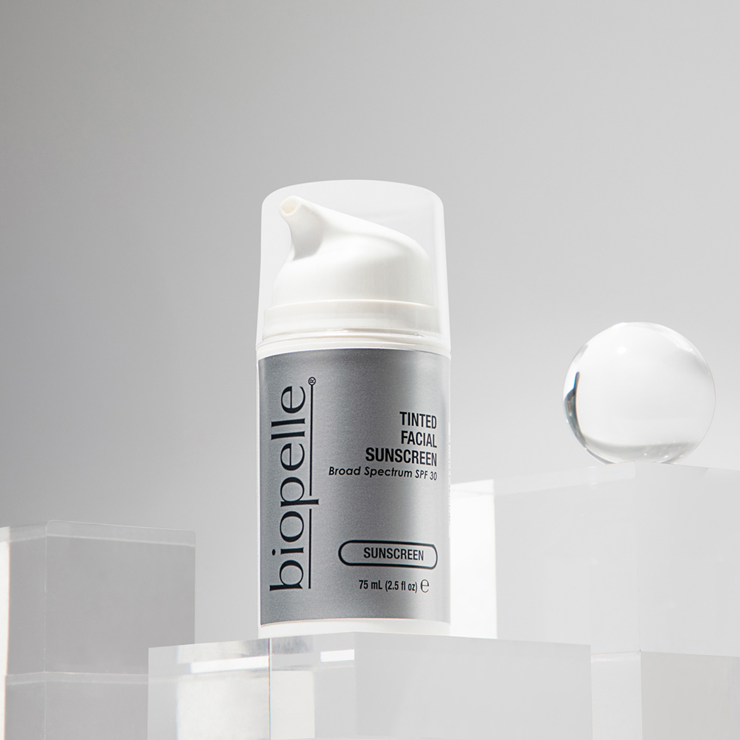 Biopelle Tinted Facial Sunscreen 75ml Broad Spectrum SPF 30 pump bottle on acrylic display with cream swatch