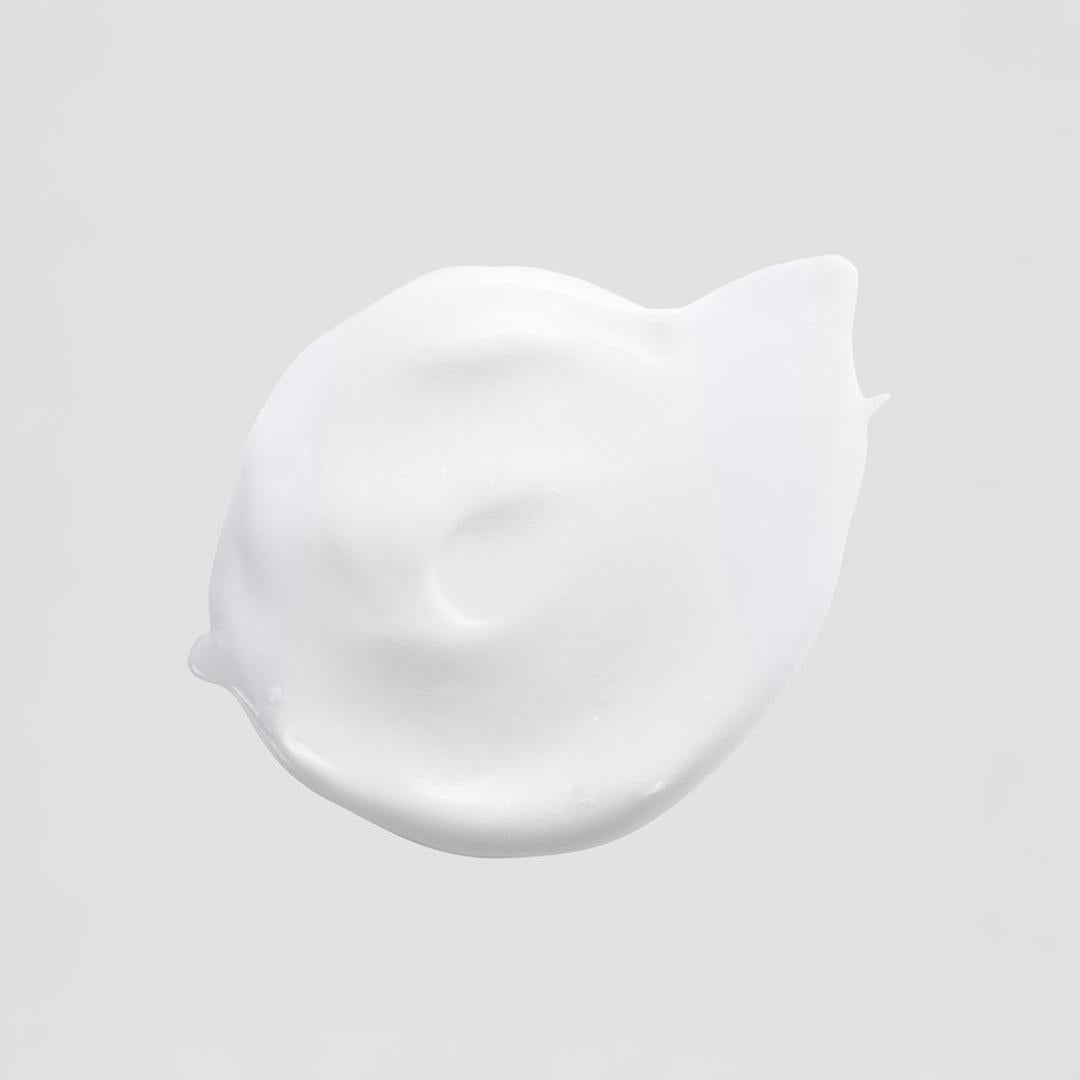 Clinical Skin Brightening Eye Cream texture close-up – rich white cream dollop on gray background showing the brightening and firming formula to illuminate dark circles and smooth fine lines