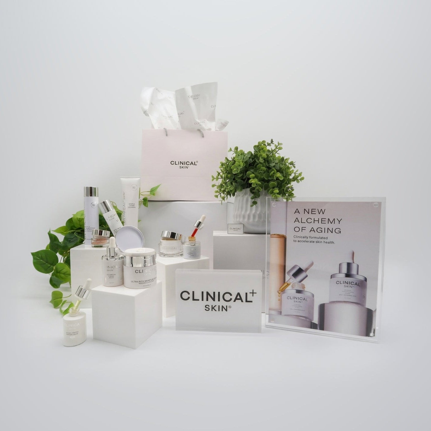 Clinical Skin Firm & Repair Reset Routine skincare collection – complete anti-aging routine with Clinical Skin serums, moisturizers, eye cream, and cleanser with branded bag and display panel on gray background