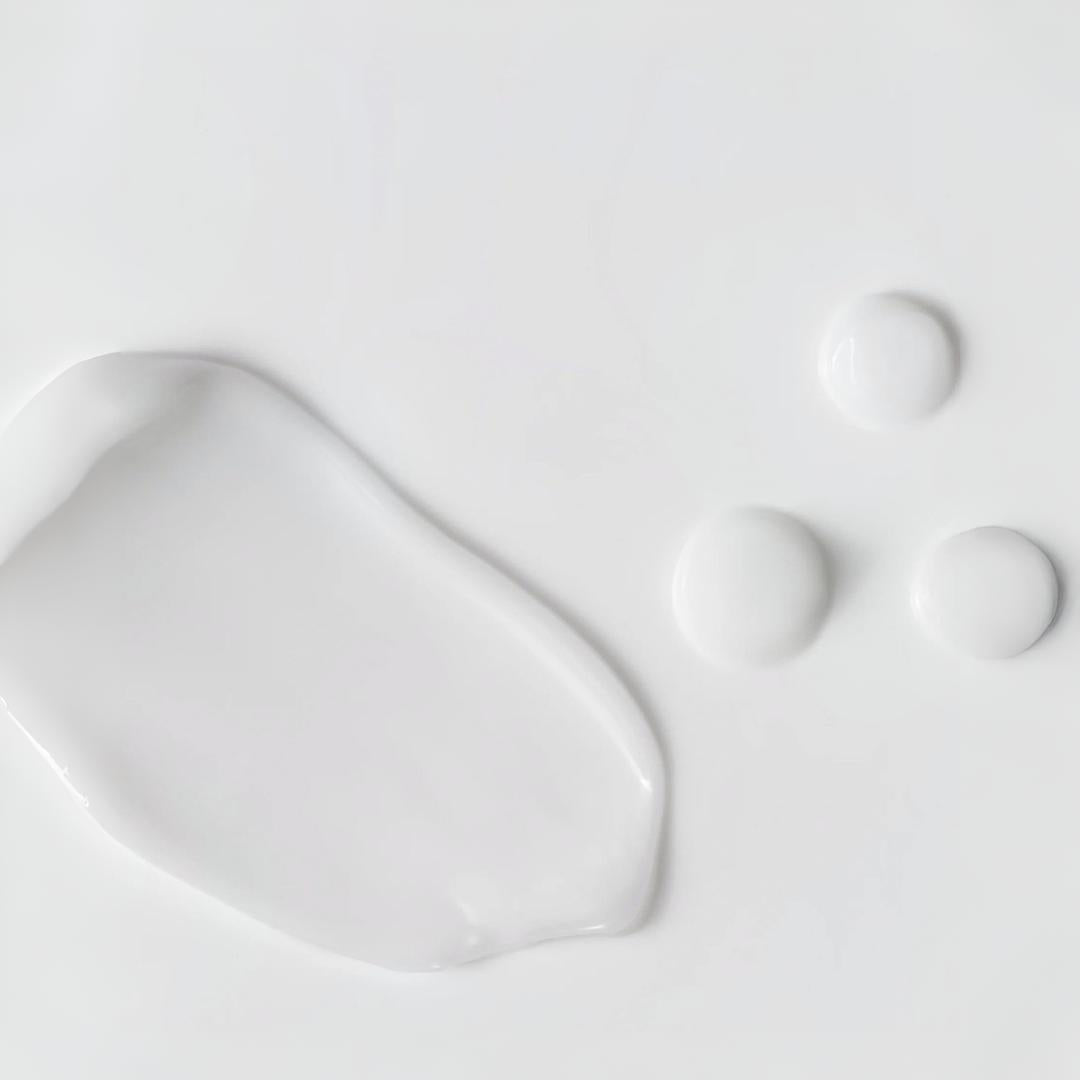 Clinical Skin Gentle Cream Cleanser texture close-up – soft white cream cleanser swipe and drops on white background showing the gentle soothing formula for sensitive skin