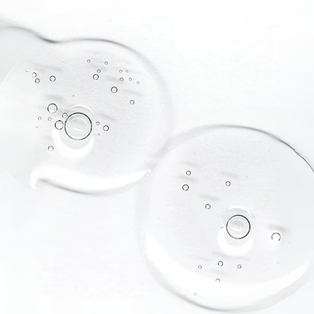Clinical Skin Hyaluronic Acid + Peptide Serum texture close-up – two clear lightweight gel drops with air bubbles on white background showing the triple hydrating complex formula for deep skin hydration