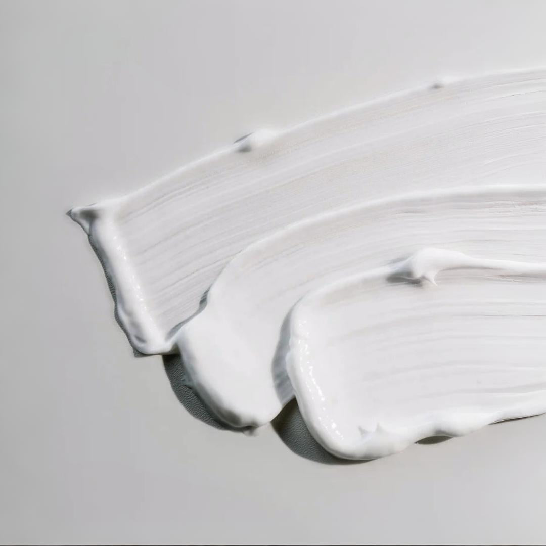 Clinical Skin Ultra-Rich Moisture Repair texture close-up – thick rich white cream smear with ridged edges on gray background showing the ultra-rich nourish and hydrate moisturizer formula