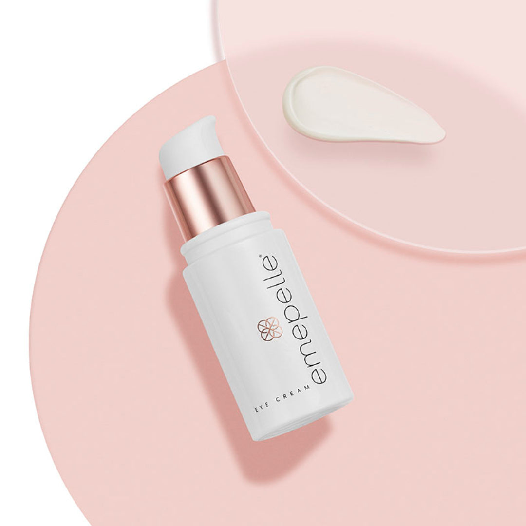 Emepelle Eye Cream on pink circle with cream swatch – lightweight under-eye treatment with MEP Technology and Peptides to reduce fine lines and puffiness