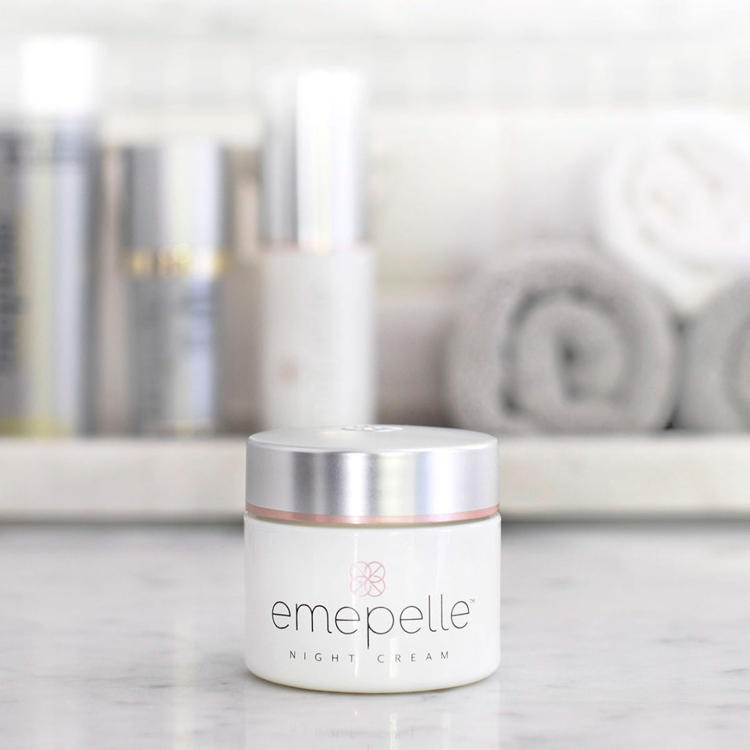 Emepelle Night Cream jar on marble countertop with skincare products in background – overnight anti-aging cream with MEP Technology for estrogen-deficient skin