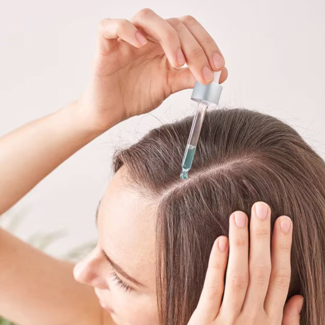 HairMax RSN8 Scalp Nourishing Serum woman applying dropper directly to scalp part