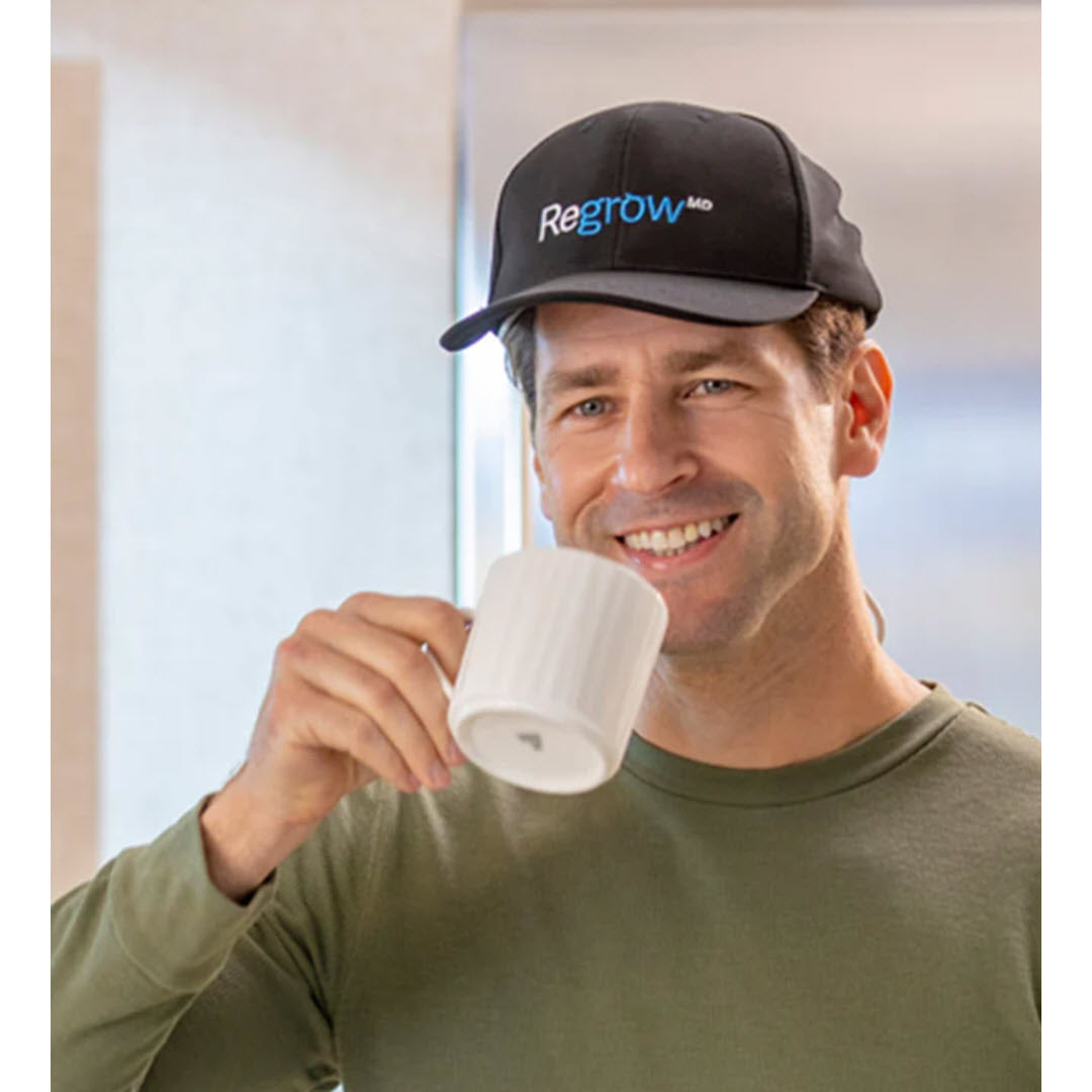 HairMax Regrow MD Laser 272 Laser Cap model wearing cap while drinking coffee