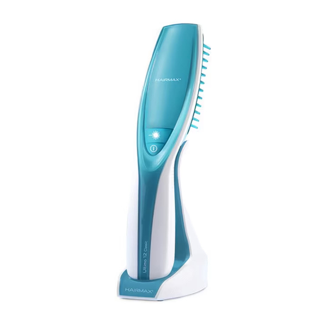 HairMax Ultima 12 Classic LaserComb Hair Growth Device teal and white laser comb on charging stand