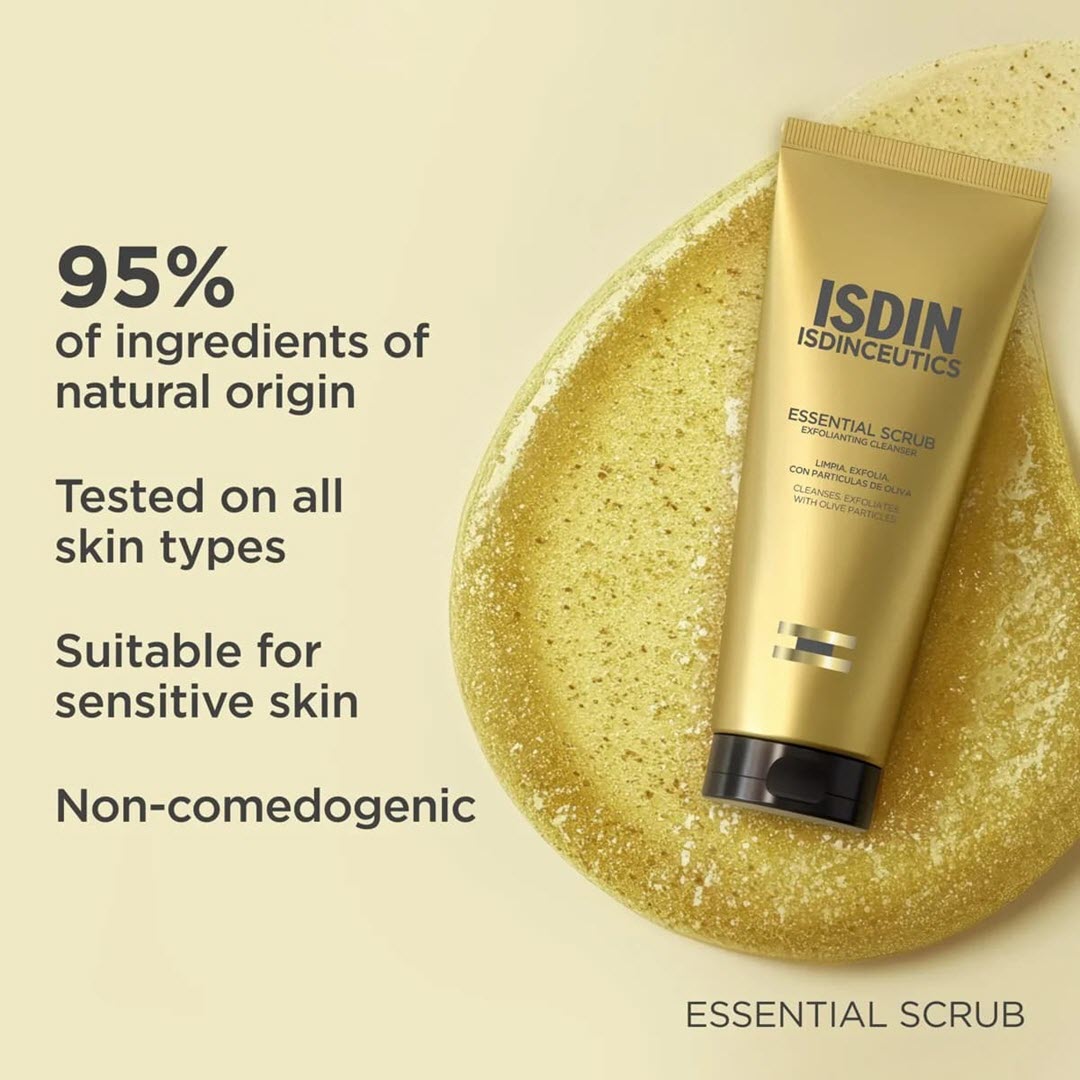 ISDIN Essential Scrub tube resting on gold exfoliating texture disc with text 95 percent of ingredients of natural origin tested on all skin types suitable for sensitive skin non comedogenic
