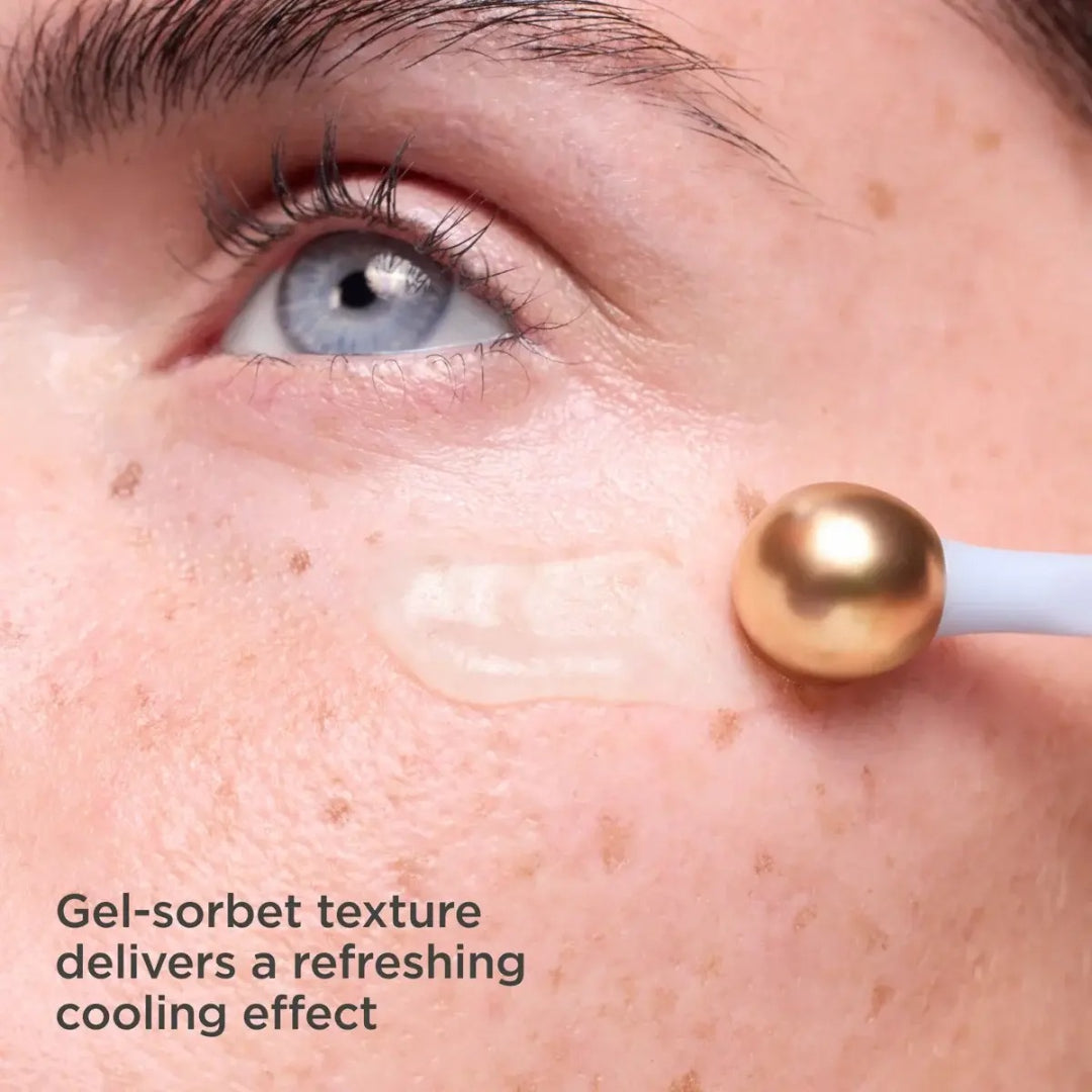 Close up of gold metal applicator dispensing ISDIN Hyaluronic Eyes gel sorbet cream under eye with text gel sorbet texture delivers a refreshing cooling effect