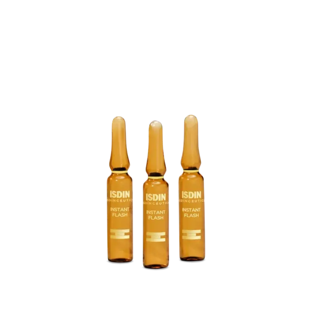 Three ISDIN Instant Flash amber glass ampoules standing upright
