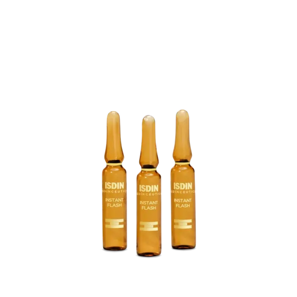 Three ISDIN Instant Flash amber glass ampoules standing upright
