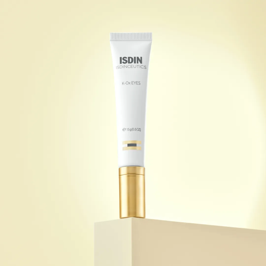 ISDIN K-Ox Eyes tube standing on cream colored pedestal