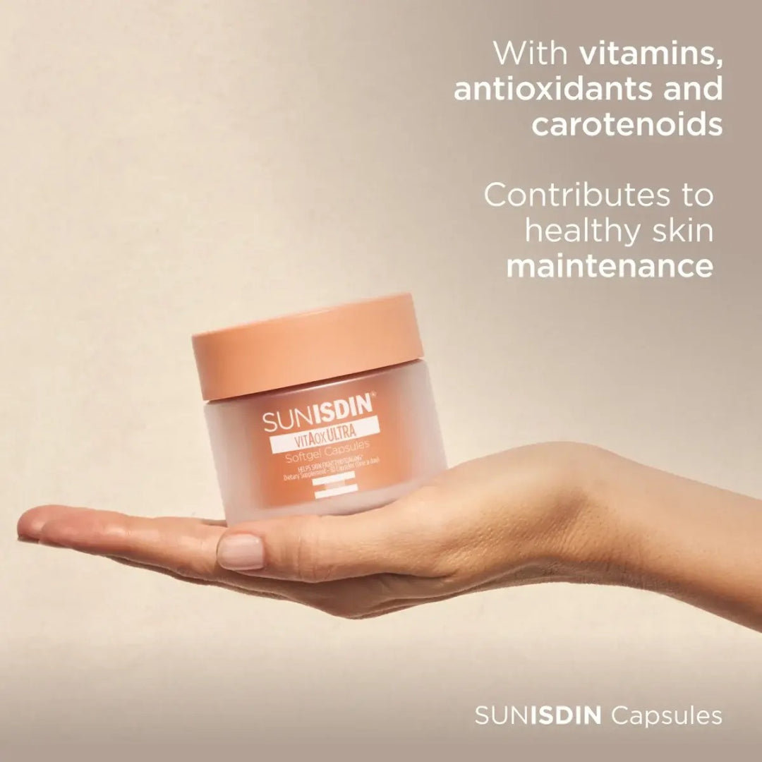 Hand holding ISDIN SUNISDIN Capsules jar with text with vitamins antioxidants and carotenoids contributes to healthy skin maintenance