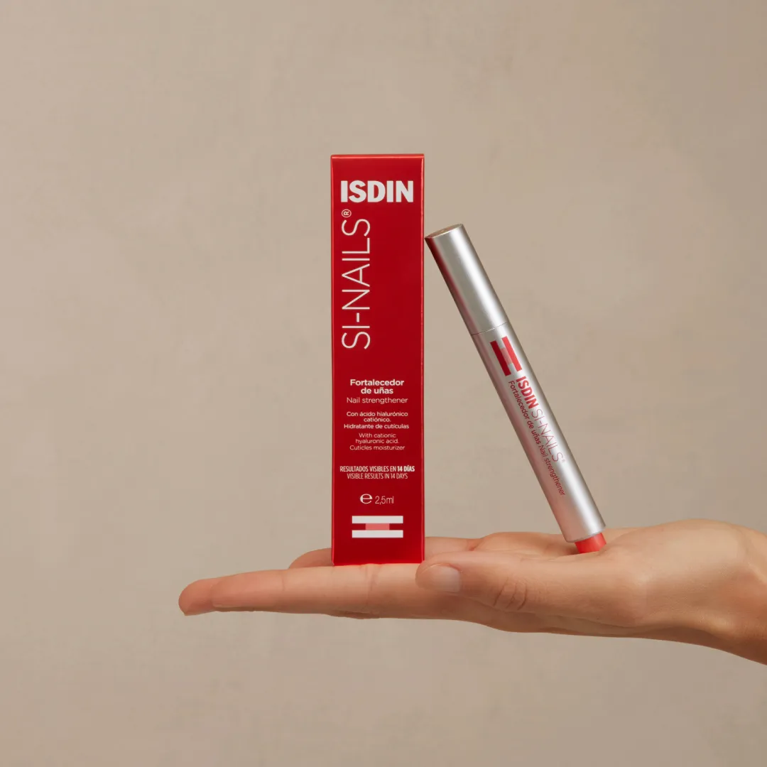 ISDIN Si-Nails pen and red retail box resting on hand