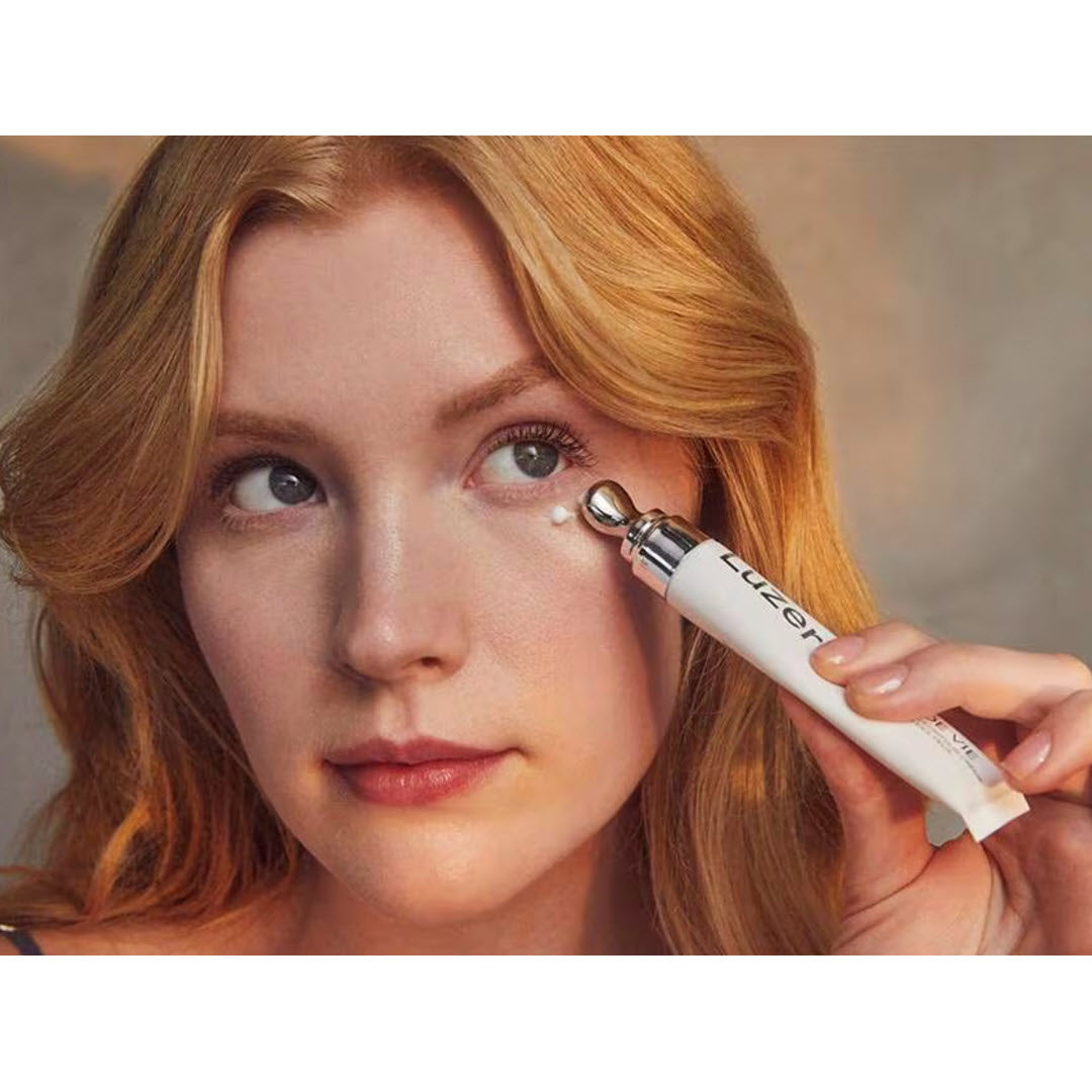 Woman applying Luzern Force De Vie Eye Contour Creme with the cooling metal applicator under her eye