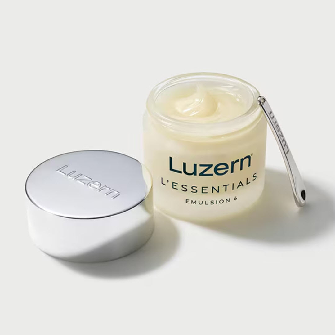 Open jar of Luzern L'Essentials Emulsion 6 Melting Balm with lid and spatula, showing creamy golden texture