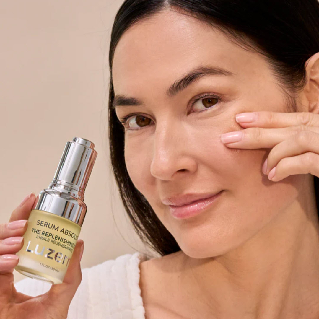 Woman applying Luzern Serum Absolut The Replenishing Oil to her under-eye area