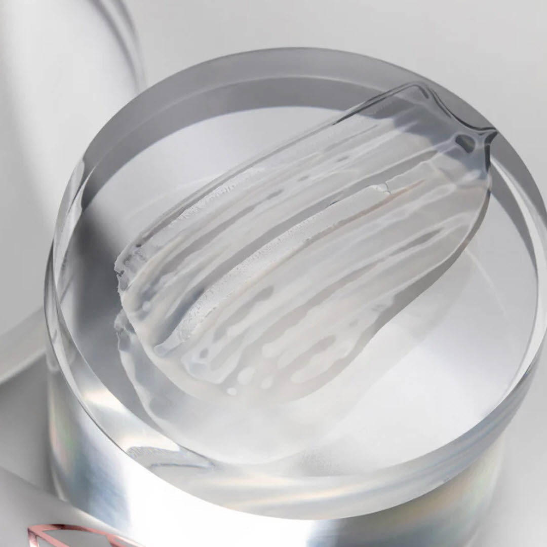 Close-up swatch of Masktini Whoa! Bye Exfoliating Booster's gel texture on a glass surface