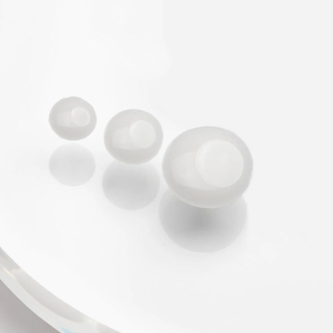 Close-up of small translucent gel beads from Masktini Whoa! Zen Balancing Booster on a white surface