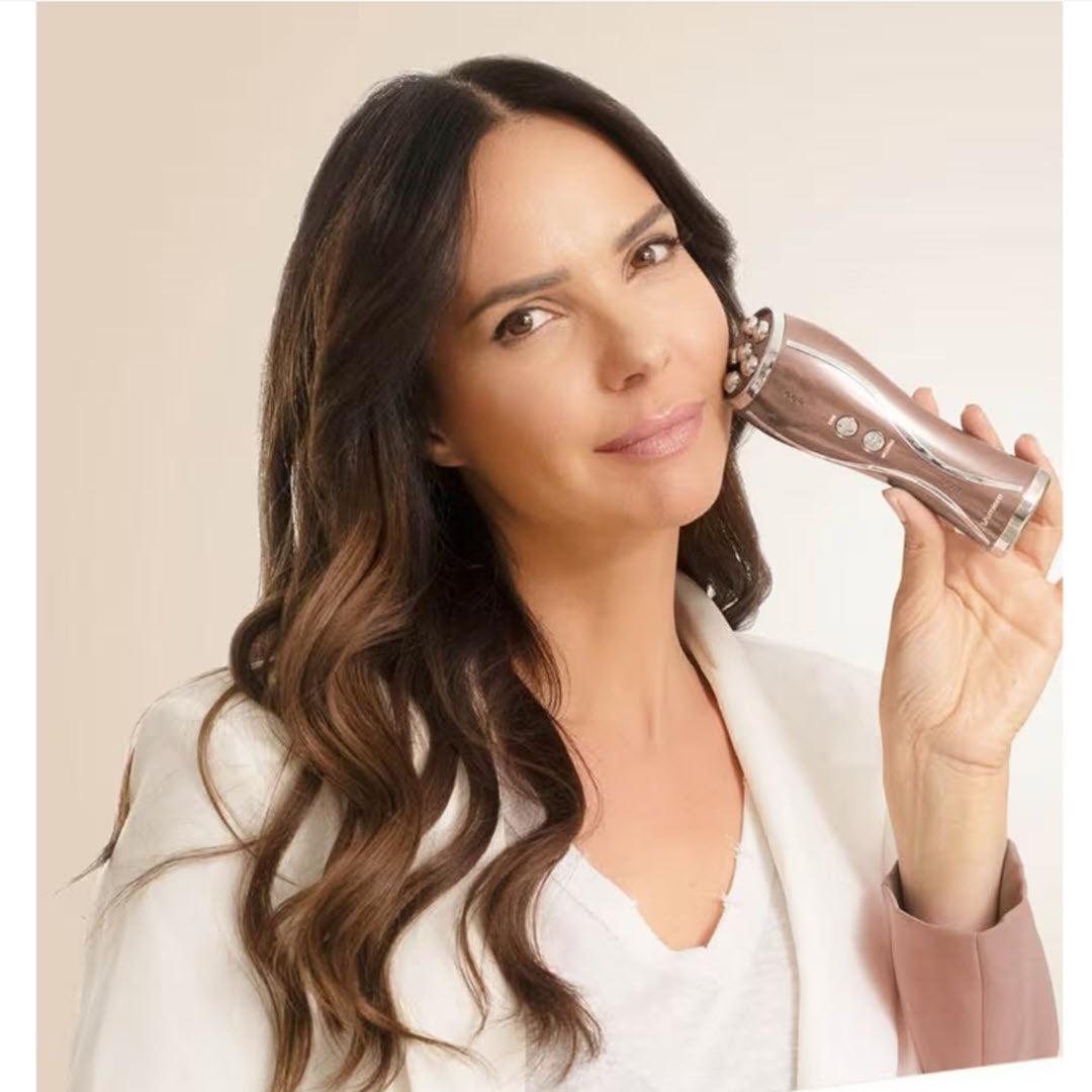 Woman using the Numiere Plus device on her cheek for microcurrent and LED facial toning