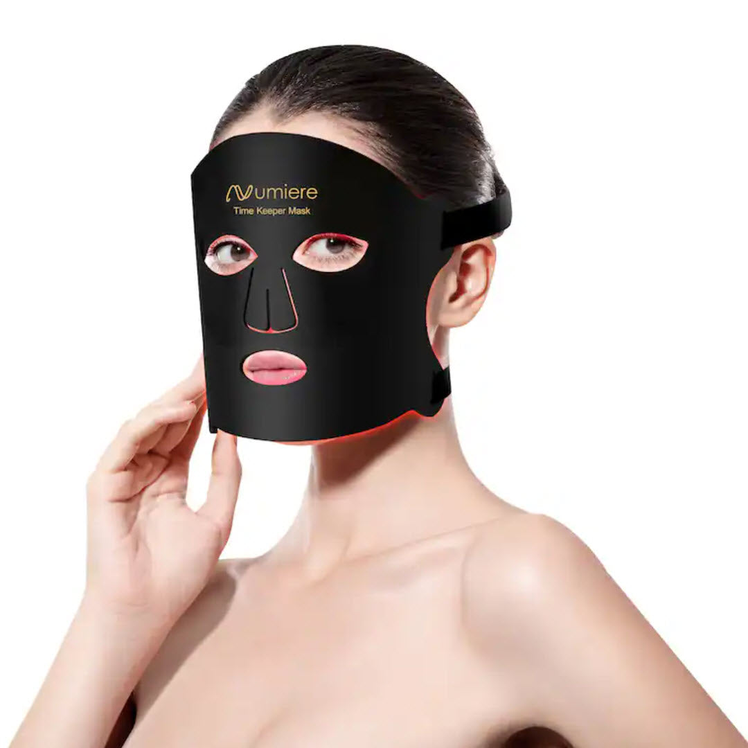 Woman wearing the Numiere Time Keeper LED Face Mask with red light therapy glowing along the edges