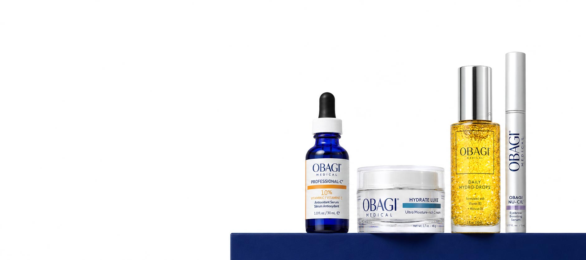 Four OBAGI skincare products arranged on a dark blue platform against a white background, including a blue dropper bottle, a white jar, a yellow oil bottle, and a white tube.