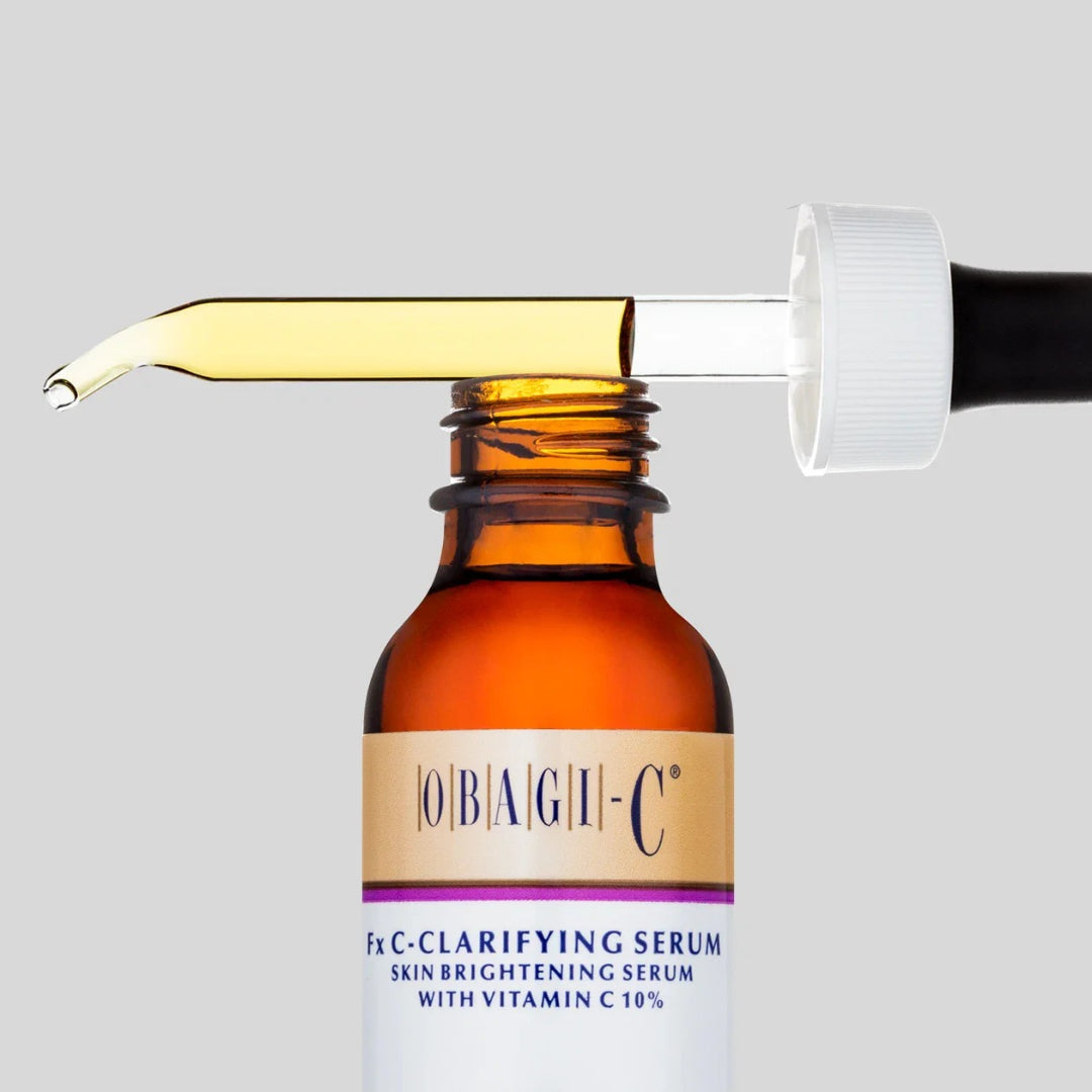 Obagi-C Fx C-Clarifying Serum amber dropper bottle open with dropper filled with golden serum close-up on gray background