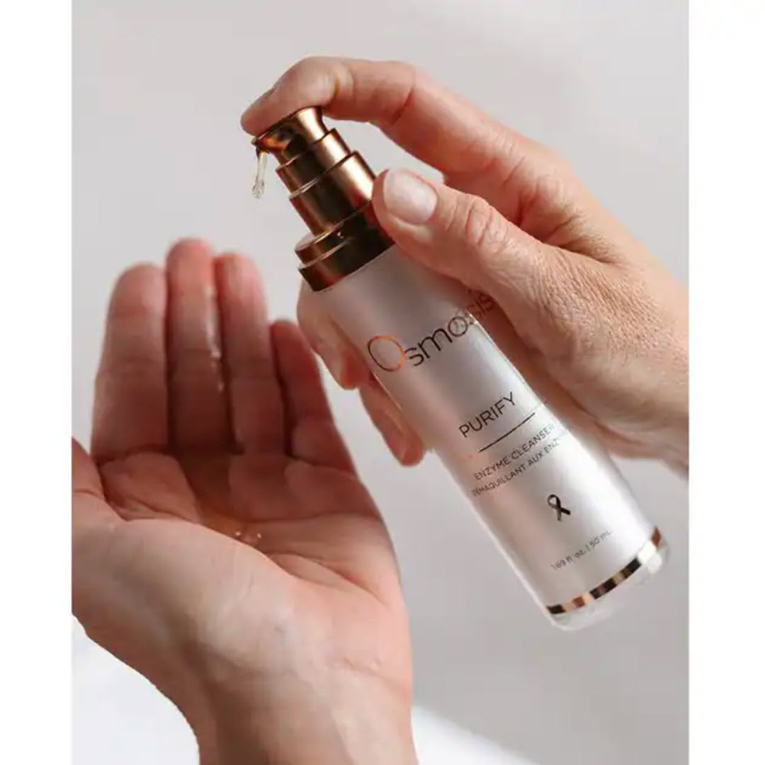 Osmosis Purify Enzyme Cleanser being dispensed from pump bottle into hand