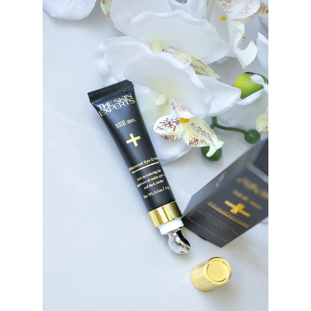 The Skin Experts SEE me. Advanced Eye Cream tube with cooling metal applicator, styled with box and white orchids