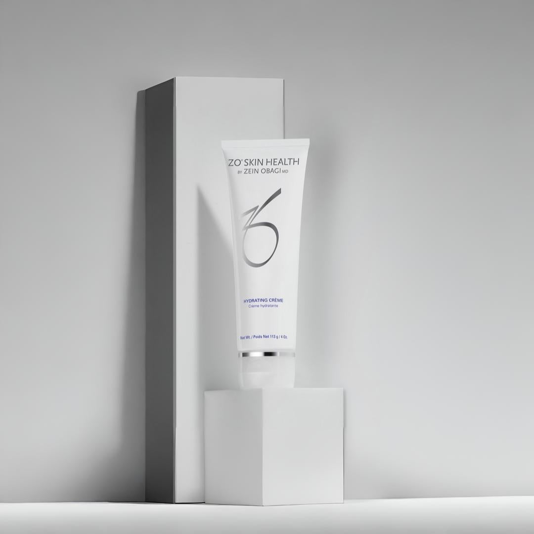 ZO Skin Health Hydrating Crème 113g tube on white geometric blocks against gray background – nourishing moisturizer for long-lasting hydration