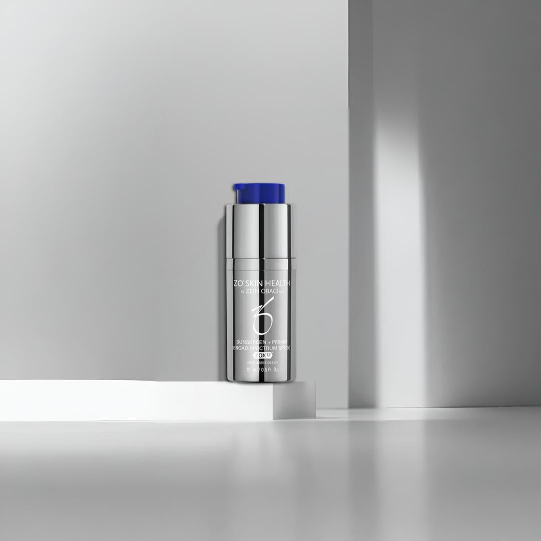 ZO Skin Health Sunscreen + Primer SPF 30 silver pump bottle on geometric white platform against gray backdrop – 2-in-1 daily primer with broad spectrum protection
